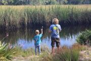 Two young boys fish from the bank on Tide Creek, a tide-influenced tributary to greater Ochlockonee River.