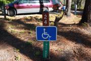 A rustic 4 feet by 4 feet wood post with signage designating Site 24 as a full access ADA site.