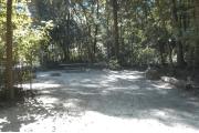 This view is from the left of the entrance with site marker #34 showing.  This is a back-in site that can accommodate campers up to 25 feet in length.  The site is surrounded by mixed hardwood trees and shrubs.  You can see a picnic table toward the back of the site.