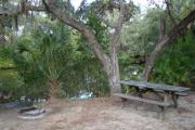 View of picnic table and grill on creek