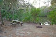 View of picnic table and grill on creek bank