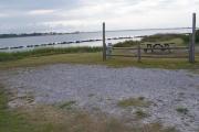 A picnic table and fire pit sit to the left in a nice grassy area. Views of the lagoon are present from all angles looking north.