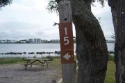 Old large oaks provide a canopy above a site that takes the shape of a peninsula. The entire length of site fifteen completely faces the Grand Lagoon and a small rock sea wall.
