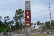 This accessible paved site is wide and open and great for maneuvering. A fire pit, an accessible grill and picnic table are located to the left.