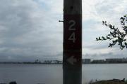 Sign post twenty four is located to the right. Sign post connect to another post with a clothes line tied between them. Electrical post and water spigot are located just to the right of the post.