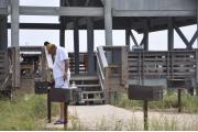 Photo shows a gentleman using one of the grills at one of the beach use area pavilions.