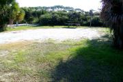 View from the front showing the picnic table and fire ring in the grassy area in the back of the site.