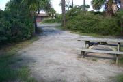 View from the back showing the picnic table in the foreground and the bathhouse across the street.