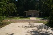 View of campground road from campsite with nearby restroom.