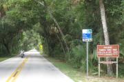 A motorcyclist cruises thru the tunnel of trees on the Ormond Scenic Loop and Trail, a designated Florida Scenic Highway that meanders thru the Tomoka Basin State Parks.