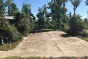 Full view of campsite 9 from road showing picnic table. Electrical hookup is located on the right side and water hookup is located on the left side of site.