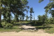 Full view of campsite 25 from road. Electrical hookup is located on the right side and water hookup is located on the left side of the site