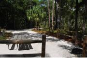 This view is from the back of the site looking onto the campground road.  The fire ring/grill is located in the back corner of the site and the site is surrounded by sections of split rail fence.