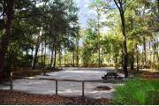 This photo is from the back of the site and shows the campground road.  The fire ring/grill is located in the back corner of the site and the site is surrounded by sections of split rail fence.