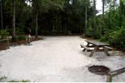 This photo is from the back of the site and shows the campground road.  The fire ring/grill is located in the back corner of the site and the site is surrounded by sections of low, split rail fence.
