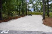Campsite #21 at Wekiwa Springs State Park has a crushed shell surface and is surrounded by sections of split rail fence and trees creating partial shade on the site.  A picnic table and in-ground fire ring/grill are provided on the site along with water and 30amp electrical service.