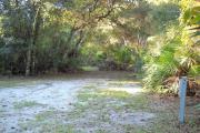 36x34 foot shell rock camp site with water and electric hook ups surrounded by saw palmetto.