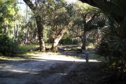 43x17 foot shell rock site with water and electric hook ups on right side. Picnic table and two oak trees in rear.