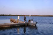 A view of a boater launching his boat from the floating dock on the lake.