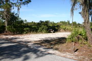 In LOOP 1 #12, a better view of the entrance to the site more palmetto and trees surround the site. Site Marker is on the right side of the main road