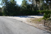 In LOOP 1 #23, a better view of the entrance to the site more palmetto and trees surround the site. Site Marker is on the right side of the main road