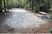 A September view of the campground drive from within campsite #10.  The water hookup is seen on the left, picnic table and lantern post are seen on the right.  Another campsite is visible across the campground drive.  Site is surrounded on three sides by a mixed oak, pine, and cabbage palm forest.