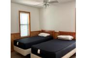 Cabin #6 at Blue Spring State Park showing a bedroom with one double bed, nightstand and lamp.