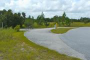 A 85 feet long gravel pull through campsite with a sitting area across from the water and electric hookups.