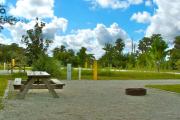 A gravel sitting area with a cast-iron fire circle and a wooden picnic table.