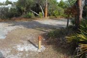 Looking at campsite marker #10; site is mostly grass and sand