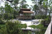 A tranquil moment at a pavilion with canoes, a boardwalk, and glass-like water at Big Lagoon State Park.