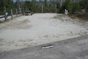A view of the campsite with a shell/sand base and native vegetation.
