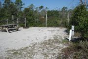 View of the campsite in bright sunshine with vegetation in the rear.