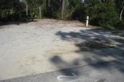 A view of the campsite with a shell/sand base and mostly shade.