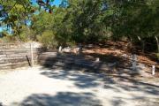 View of a wooden retaining wall and clothesline in partial shade.