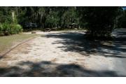 Campsite number 18 has a small border of trees between the site and the circle drive. The picnic area is visible to the left and the table and fire ring can be moved around.
