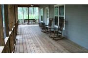 This picture of cabin 2 is taken where the screened in porch makes an L. The porch is L shaped and runs the full length of both sides of the cabin. The porch has a wooden picnic table, chairs and a swing for your use as pictured. The porch has two access doors, one from the kitchen and the other is on the back side (other part of L shaped porch) between the fireplace and bedroom walls.