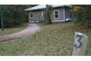 This view of cabin site marker is for cabin number 3. Also pictured is the walkway up to the cabin as viewed from the three space parking lot. The gas tank is for the gas fire place. The cabins are total electric.