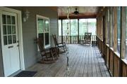 This picture of cabin 3 is taken on the porch from behind the swing. Also pictured are the two rocking chairs that is common to cabins 1-4. The porch is L shaped and runs the full length of both sides of the cabin. The porch has a wooden picnic table, chairs and a swing for your use. The porch has two access doors, one from the kitchen and the other is on the back side (other part of L shaped porch) between the fireplace and bedroom walls. The kitchen has a refrigerator, stove, range top, sink and dishwasher.