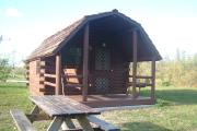 Photo: OLETA RIVER SP. Cabin #14 with swing on the porch and a picnic table outside.