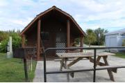 Photo: 001, PRIM. Cabin #1 at Oleta River has a porch swing, a picnic table and a barbeque grill.