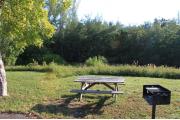 Photo: 012, PRIM. Cabin #12 at Oleta River has a barbeque grill and a picnic table.