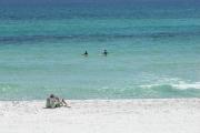 A family enjoying a day at the beach and swimming in the emerald water at Henderson Beach.