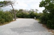 Deep campground site with picnic table and water and electric hookups.