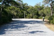 Campsite with picnic table, fire ring and clothes lines poles.