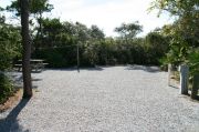 Picnic table with clothesline in campsite. Electric and water hookups are on the right.