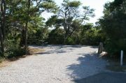 Picnic table with clothesline in campsite. Electric and water hookups are on the right.