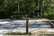 Close-up photo of the brown with white site number sign on a wooden post.