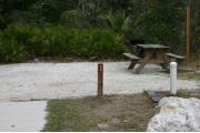 Close-up photo of the brown with white site number sign on a wooden post.