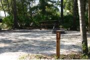 Close-up photo of the brown with white site number sign on a wooden post.